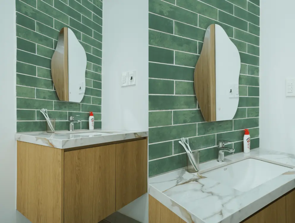 Khu vực lavabo sử dụng mặt đá vân mây kết hợp gạch thẻ xanh làm điểm nhấn